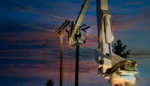 A lineman fixing a power line failure at sunset with a spotlight on them